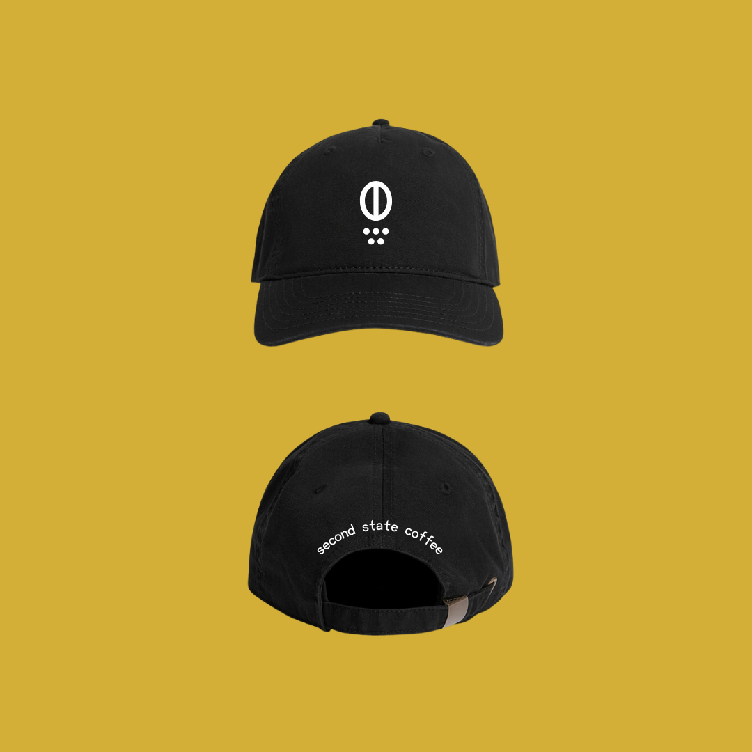 front and back image of black 6 panel hat. front features visual icon for coffee bean and grounds. back features words "second state coffee"